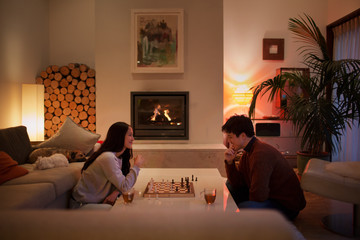 Couple playing chess in living room