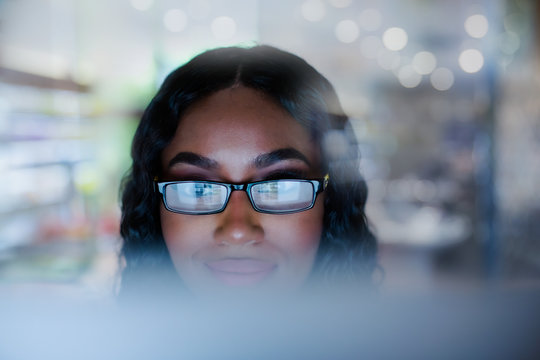 Young businesswoman in eyeglasses working at computer