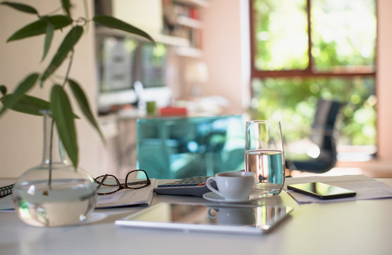 Digital tablet on table with coffee and calculator