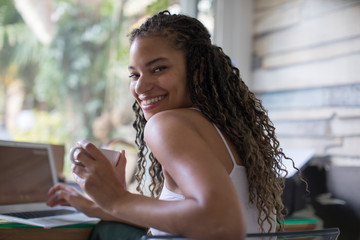 Portrait happy young female freelancer working at laptop