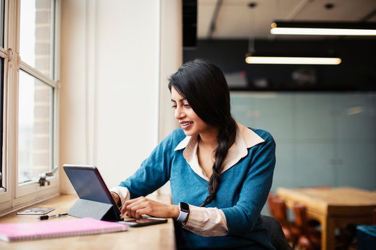 Businesswoman working at digital tablet in office - Powered by Adobe