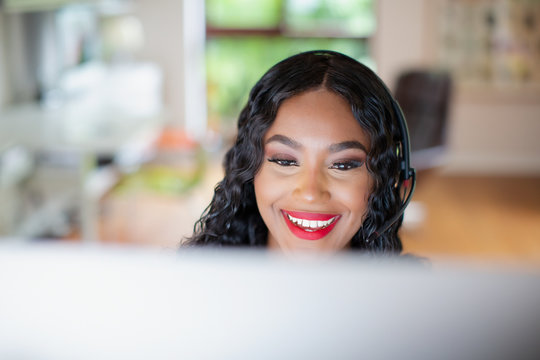 Young woman with headset working at computer