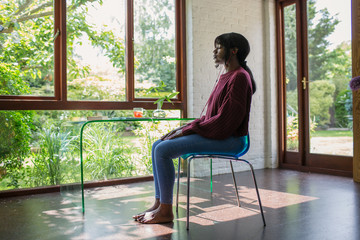 Serene young woman meditating in tranquil home office