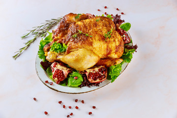 Roasted turkey on plate with herbs and pomegranate.