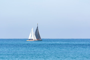 two sailboats are sailing out to sea
