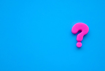 pink question mark on a blue background. Background photo with place for text.