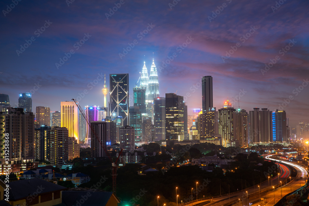 Wall mural Kuala Lumpur City skyline and skyscraper with highway road at night in Kuala Lumpur, Malaysia. Asia. Malaysia tourism, modern city life, or business finance and economy concept