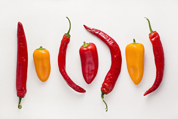 Colorful chili peppers on white background. Red, yellow, hot and sweet bell peppers. Spicy food...