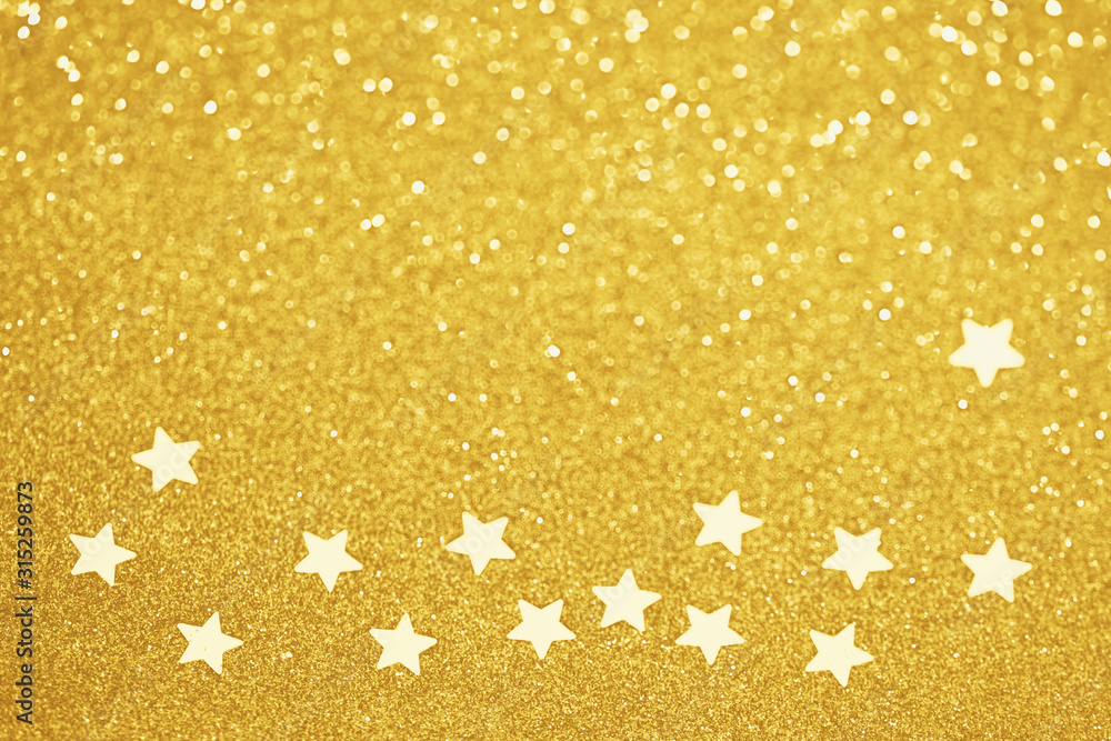 Sticker gold star confetti glitter background. shiny holiday golden decoration. defocused bokeh lights