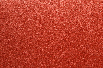 Red glitter texture festive background.  Blurred sparkle lights. Holiday decorative backdrop