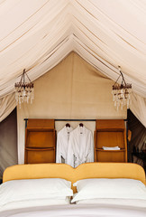 Luxury Safari tent camp bedroom interior in Serengeti Savanna forest - Glamping travel in Africa...