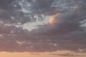 Obraz premium beautiful section of cloud filled sky at golden hour showing blue, grey, gold, yellow and orange hues at sunset during Australian summer