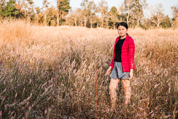 Naklejka na ściany i meble The girl is traveling in the grass field cockscomb grass.