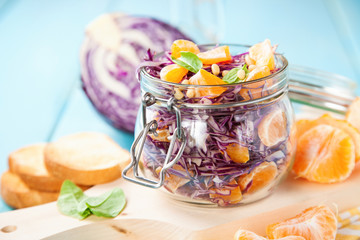 Red cabbage tangerines and pine nuts salad. Selective focus. Copy space.