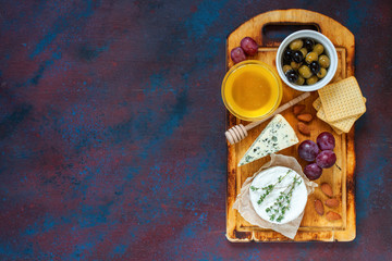 Cheese, honey and fruit on a table. Selective focus. Top view. Copy space.