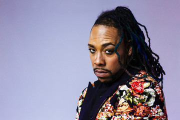 Studio portrait of a man wearing a flower patterned suit and dreadlocks