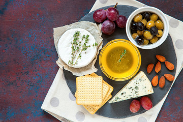 Cheese, honey and fruit on a table. Selective focus. Top view. Copy space.