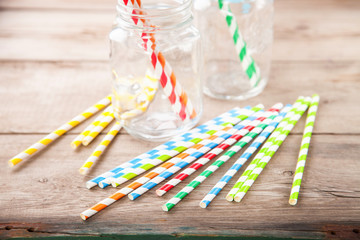 Colorful paper straws on wooden background. Event and party supplies. Selective focus. Copy space