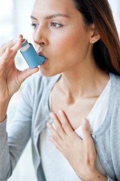 Young woman using inhaler