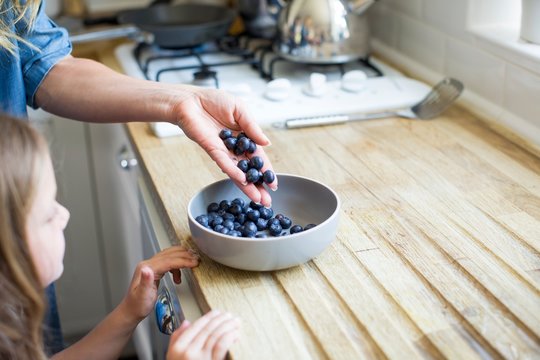 Girl looking at bowl of fresh blueberries