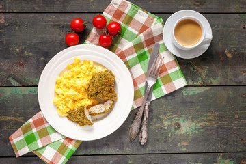 Breakfast - an omelet, chicken fillet in a green breading and coffee on a table. Selective focus. Top view. Copy space.