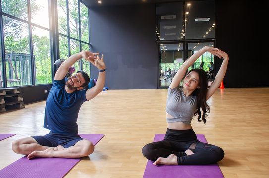 Young healthy woman and man  practicing yoga on fitness class background, Harmony, balance, meditation, relaxation, healthy lifestyle concept
