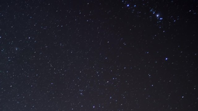 Time lapse of Orion star constellation at night with shooting star, zoomed