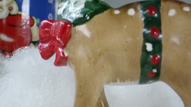 Jib Up Macro Shot Of A Small Christmas Reindeer Toy Surrounded By Fake Snow