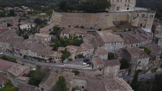 Aerial pan left up Grignan village in provence at sunrise from above france