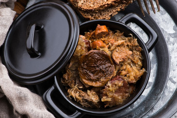 Traditional polish sauerkraut (bigos) with mushrooms and plums for christmas