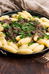 Freshly cooked, Polish traditional potato dumplings serving with mushroom sauce and fresh parsley