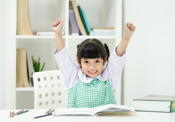 education, elementary school, learning and student concept. Happy successful student hands raised up to celebrate the successful mark of education test.  