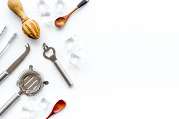 Bar utensil, tools - shaker, stainer - near ice cubes on white background top-down frame copy space