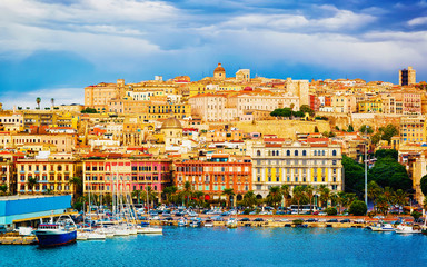 Old Sardinian Port with ships at Mediterranean Sea and city of Cagliari, South Sardinia Island in Italy in summer. Cityscape with marina and Yachts and boats in town