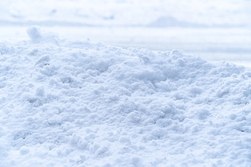 Fototapeta na wymiar Thick pile of white soft snow covers concrete wall