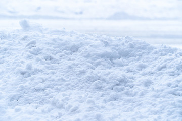 Thick pile of white soft snow covers concrete wall