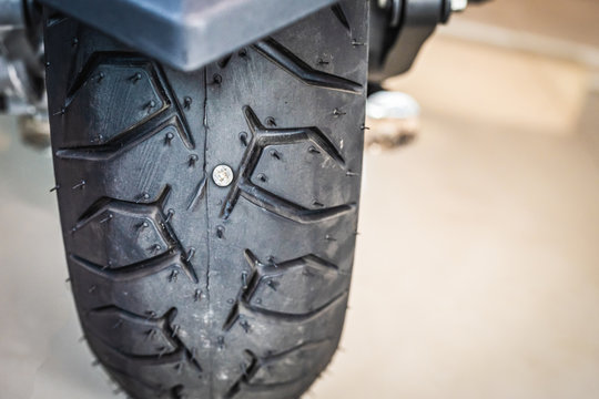 screw nail or Iron stuck puncturing motorcycle or big scooter tire at a  motorcycle repair shop. Selective focus.motorcycle repair and service and  maintenance concept foto de Stock | Adobe Stock