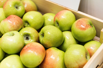 Green apples in a wooden crate.