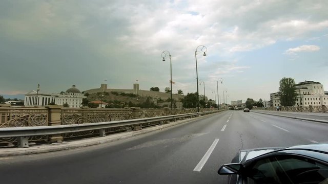 Pov of car driving on city road in Skopje, Macedonia. View of National museum, Kale fortress