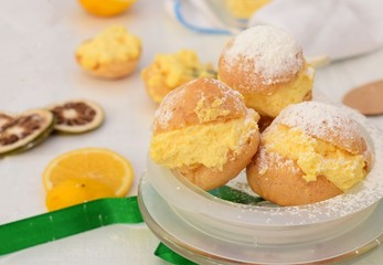 Vanilla and orange cream cakes at light wooden background/ Princess donuts dessert