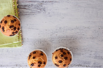 Sweet delicious homemade vanilla muffins whit chocolate chips at white wooden background