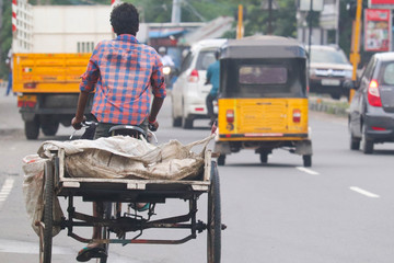 Close Up Of Garbage Collection Boy Pulling Manually Operated Rickshaw Loaded With Waste Materials...