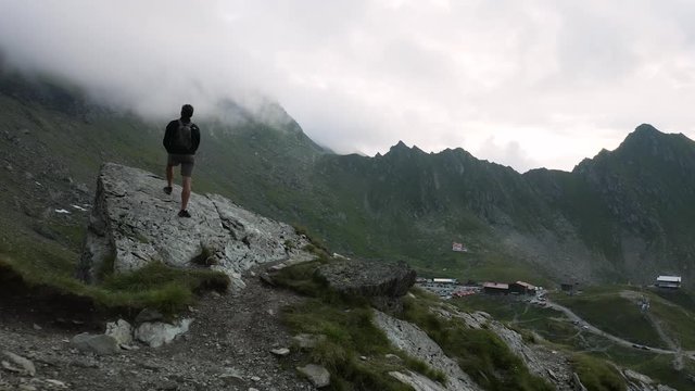 4K Man Overlooks Transfagarasan Road in Romania Romanian Highway Drone