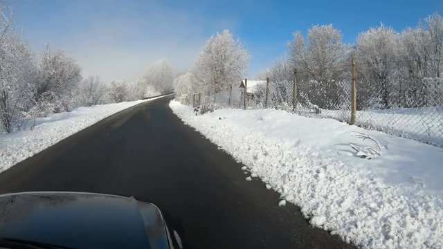 scenic veiw of driving on empty road with snow covered landscape while snowing in winter season