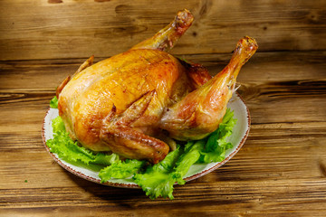 Baked whole chicken on a wooden table