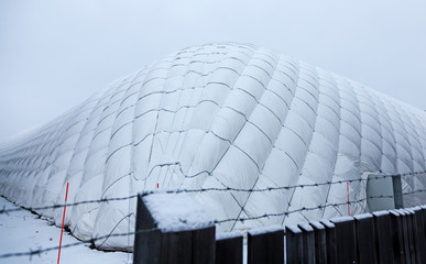 Umea, Norrland Sweden - December 20, 2019: large football tent behind barbed wire on which it snowed