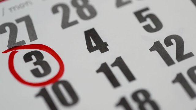 The hand encircles date 3 on the calendar. A red marker marks the number 3. Close-up.