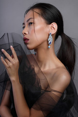 Beauty portrait of a beautiful asian girl with black transparent fabric.