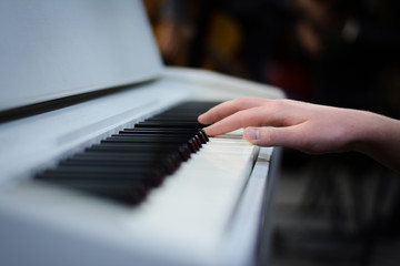 Obraz premium hand playing piano, white piano keys, black and white keys and hand