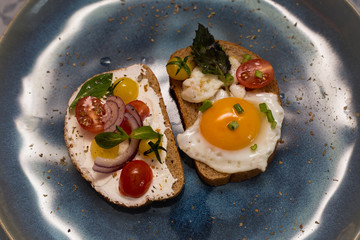 Morning breakfast toast with egg, bread, cherry tomatoes, onion, and cheese.